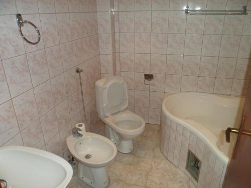 a bathroom with a toilet and a sink and a tub at Hostel Olimpik in Negotin