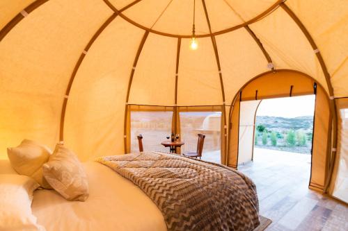 1 dormitorio con 1 cama en una tienda de campaña en la cúpula en Terrojo - Glampings de Lujo Duerme Bajo las Estrellas en Sáchica
