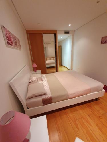 1 dormitorio con 1 cama grande y espejo en Apartamento T3-S.PedroII, en Ponta Delgada