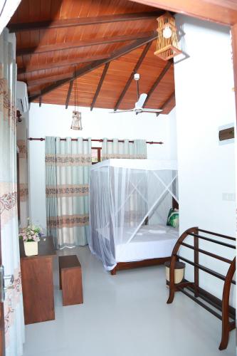 a bedroom with a bed with a mosquito net at Mango Shade in Dickwella