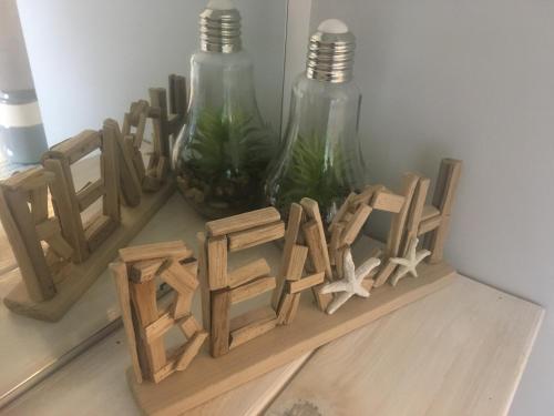 a group of wooden letters sitting next to two glass bottles at Long Lake Waterfront Bed and Breakfast in Nanaimo