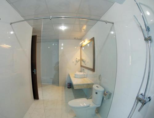 bagno con servizi igienici, lavandino e specchio di Khách Sạn Hoa Ban Trắng a Sơn La