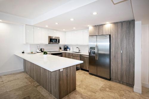 una cocina con nevera de acero inoxidable y armarios en Ocean Reserve Luxury Condos Across from Sunny Isles Beach en Miami Beach