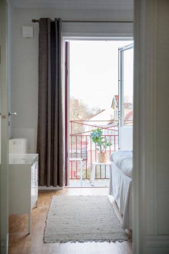 a bedroom with a large glass door to a balcony at Sköna Hönor Apartments in Visby