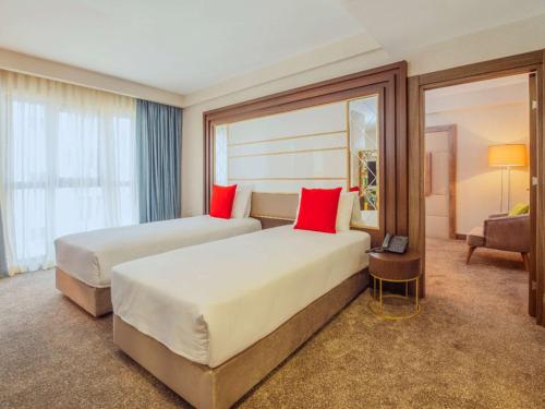 Habitación de hotel con 2 camas con almohadas rojas en ibis Styles Istanbul Bomonti, en Estambul