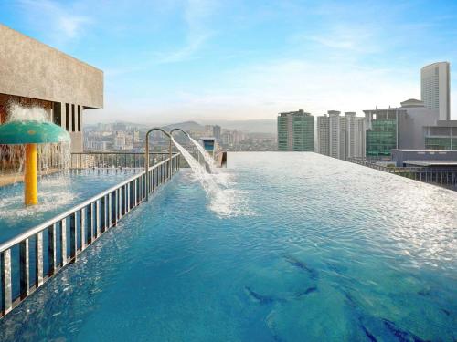 a pool with a water slide on top of a building at ibis Kuala Lumpur City Centre in Kuala Lumpur