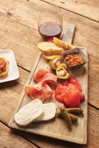 a wooden cutting board with vegetables and a glass of wine at Hyatt Place Denver Tech Center in Centennial