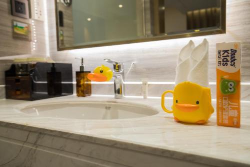 a bathroom sink with a rubber duck on the counter at Kunming Golden Spring Hotel in Kunming