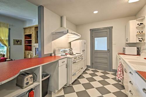 a kitchen with white appliances and a checkered floor at Remodeled Retro Home with Deck, Walk to Main Street! in Blanco