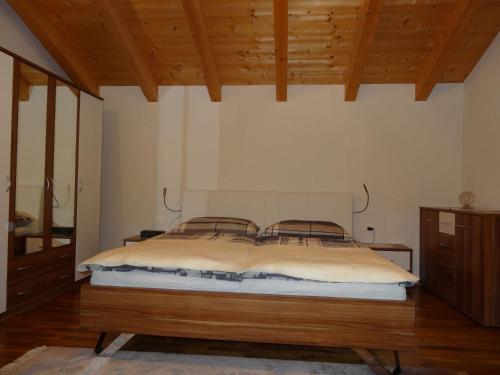 Un dormitorio con una cama grande en una habitación con techos de madera. en Ferienwohnung Irmgard, en Steinberg am Rofan