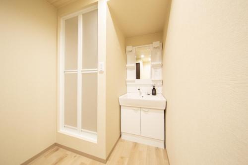 a white bathroom with a sink and a mirror at Gummi 駅徒歩12分 USJ電車1駅 EXPOシャトルバス2駅 梅田4駅 in Osaka