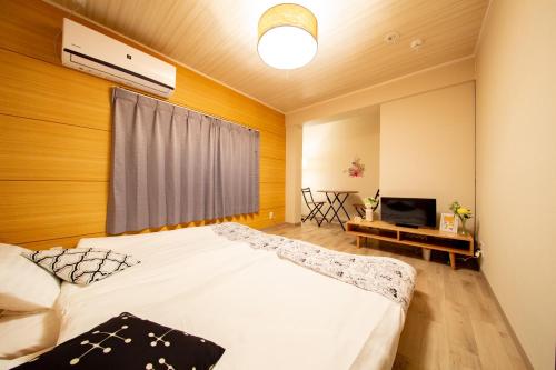 a bedroom with a large bed and a television at Gummi 駅徒歩12分 USJ電車1駅 EXPOシャトルバス2駅 梅田4駅 in Osaka
