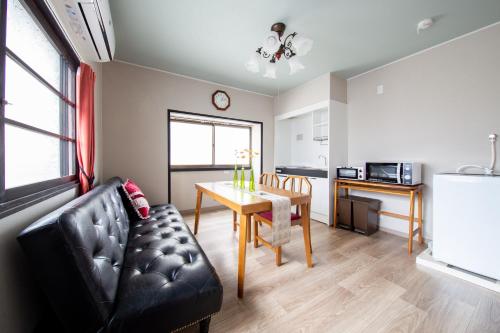 a living room with a dining room table and a kitchen at Gummi 駅徒歩12分 USJ電車1駅 EXPOシャトルバス2駅 梅田4駅 in Osaka