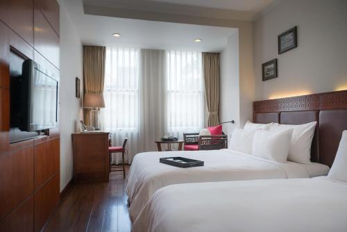 a hotel room with a bed and a flat screen tv at Hanoi E Central Luxury Hotel & Restaurant in Hanoi