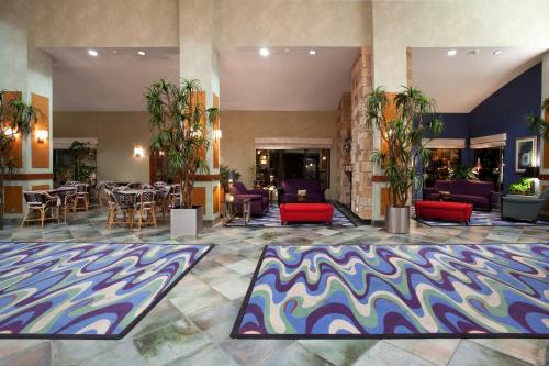 a lobby with tables and chairs and a colorful rug at Holiday Inn Rock Springs, an IHG Hotel in Rock Springs