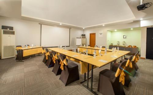 a conference room with tables and chairs and a whiteboard at Sevn Legian in Legian