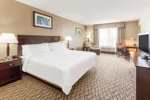 a hotel room with a large bed and a television at Holiday Inn Express Charles Town by IHG in Shenandoah Junction