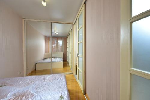 オムスクにあるОрловского 8の鏡付きのベッドルーム1室、ベッド1台が備わるベッドルーム1室を提供しています。