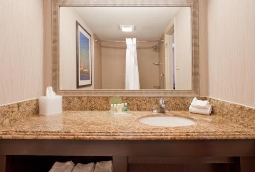 a bathroom with a sink and a large mirror at Holiday Inn Resort Galveston - On The Beach by IHG in Galveston