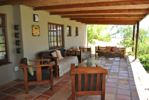 a patio with couches and chairs on a house at Heidedal Self-catering Guest House in Porterville