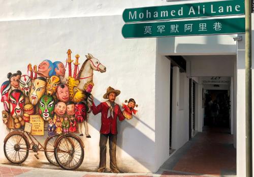 a man standing next to a bike in front of a building at BEAT Arts Hostel at Chinatown in Singapore