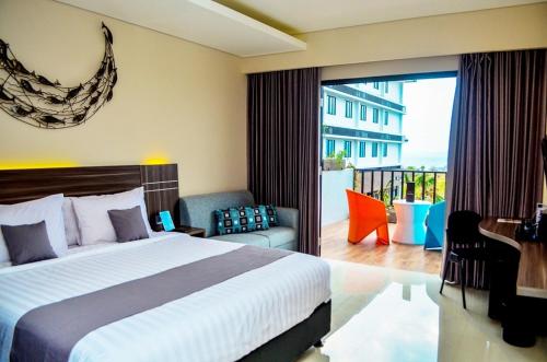 a hotel room with a bed and a balcony at Neo Eltari Kupang by ASTON in Kupang
