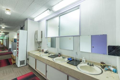 a bathroom with three sinks and two mirrors at Chojuyu Hakone in Hakone
