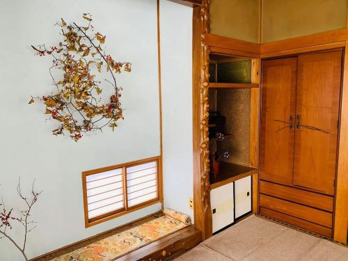 a room with a kitchen with a door and a window at ゲストハウス蘖 -ひこばえ in Kitakami
