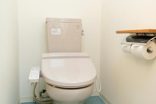 a white toilet in a bathroom with a telephone at Kumamoto Ichibamae Business Kurenai Hotel in Kumamoto