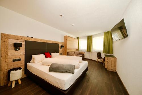 a hotel room with a large bed and a desk at Haus Alpenblick in Ladis