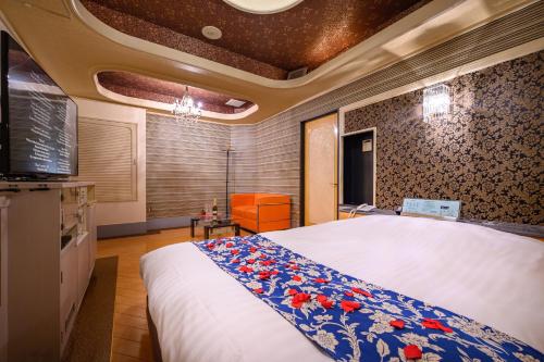 um quarto com uma cama grande e uma televisão em HOTEL MOBILIA (Adult Only) em Tsurugashima