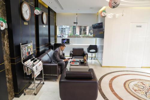 a man sitting in a chair in a waiting room at Flamingo Hotel Apartment in Abu Dhabi