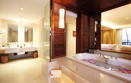 a bathroom with a tub and two sinks and a large mirror at Mövenpick Resort Bangtao Beach Phuket in Bang Tao Beach