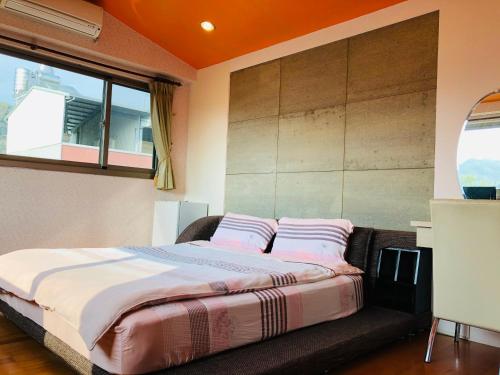a bedroom with a bed with pink pillows on it at Chong Er Ya She Homestay in Jiji