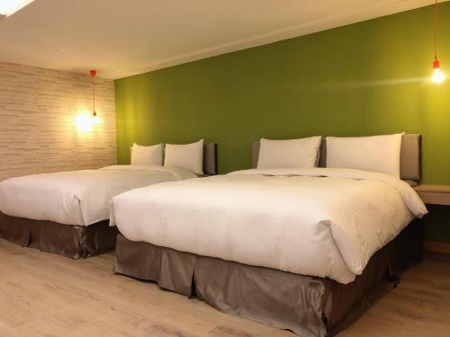 台南的住宿－台南嘉園旅店，绿墙客房的两张床