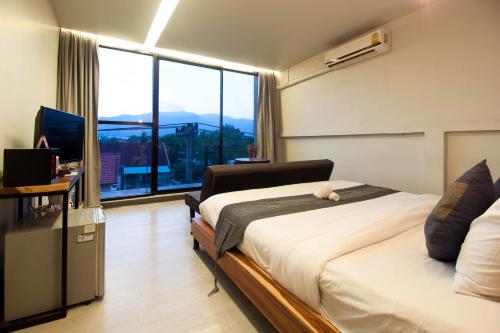 a bedroom with a bed and a large window at 3 Laan House in Chiang Mai