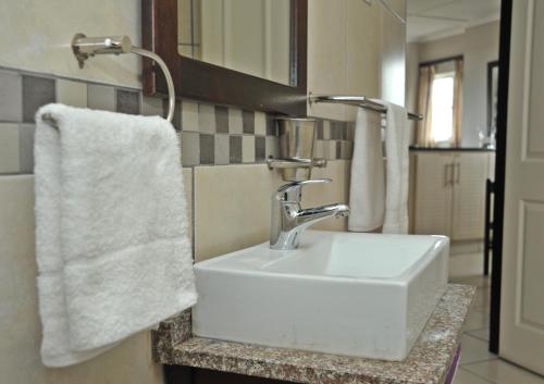 a bathroom with a white sink and a towel at Sunrise Beach Resort in Amanzimtoti