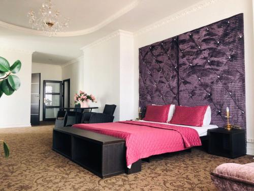 a bedroom with a large bed with a pink blanket at ArkPalmira in Odesa