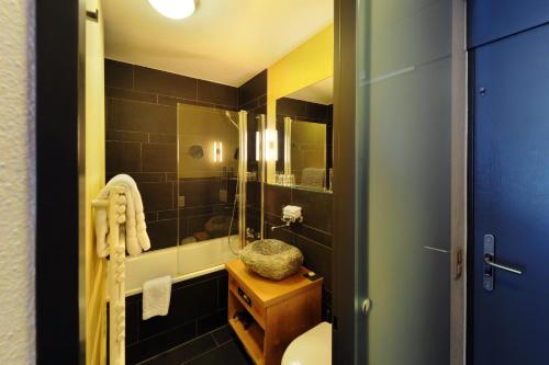 a bathroom with a shower and a sink and a toilet at Eiger Selfness Hotel**** - Zeit für mich in Grindelwald