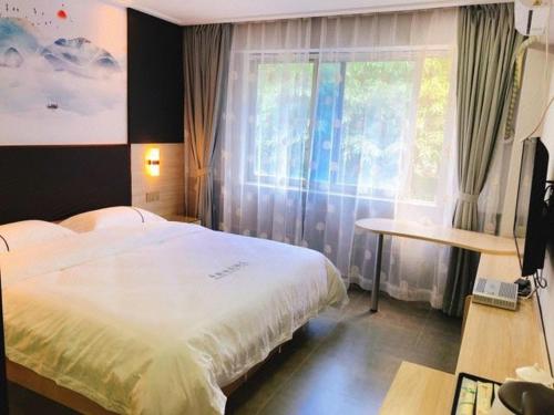 - une chambre avec un grand lit et une fenêtre dans l'établissement  Shenzhen Hualian Boutique Hotel, à Shenzhen