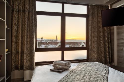 a bedroom with a large window with a view of a city at Cloud Studio in Sibiu