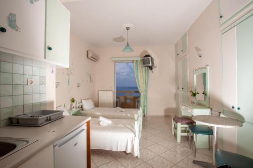 a kitchen with a bed in a room with a window at Eliza Apartments in Rethymno Town