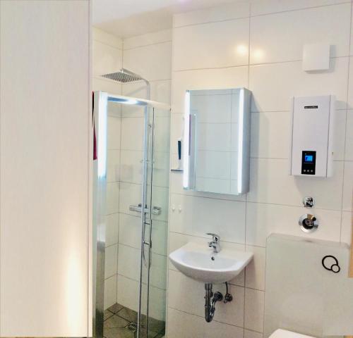 La salle de bains est pourvue d'un lavabo et d'une douche. dans l'établissement Ferienwohnung Rodenhof, à Sarrebruck