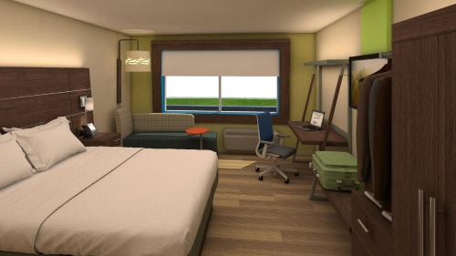 a hotel room with a bed and a desk and a chair at Holiday Inn Express Atlanta SW - Newnan by IHG in Newnan