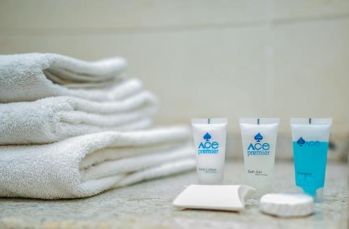 a pile of towels and two bottles of sunscreen at Ace Premier Hotel in Abuja