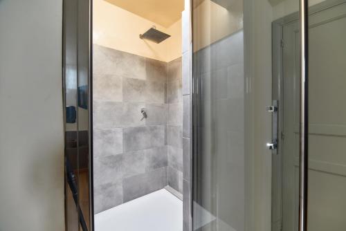 a shower with a glass door in a bathroom at L' Hôtellerie Easy Suites in Palermo