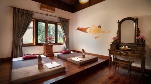 a room with three beds and a mirror and a piano at Mane Family Vacation in Siem Reap