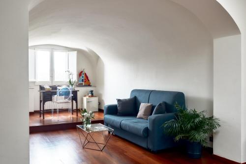 a living room with a blue couch and a table at L' Hôtellerie Easy Suites in Palermo