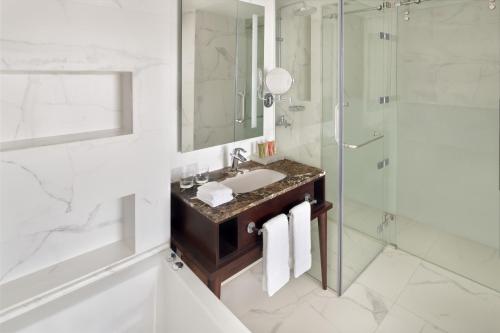 a bathroom with a sink and a shower at Mövenpick Hotel Amman in Amman