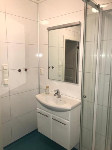 a white bathroom with a sink and a mirror at Waterfront Twin Cabin in Stamsund